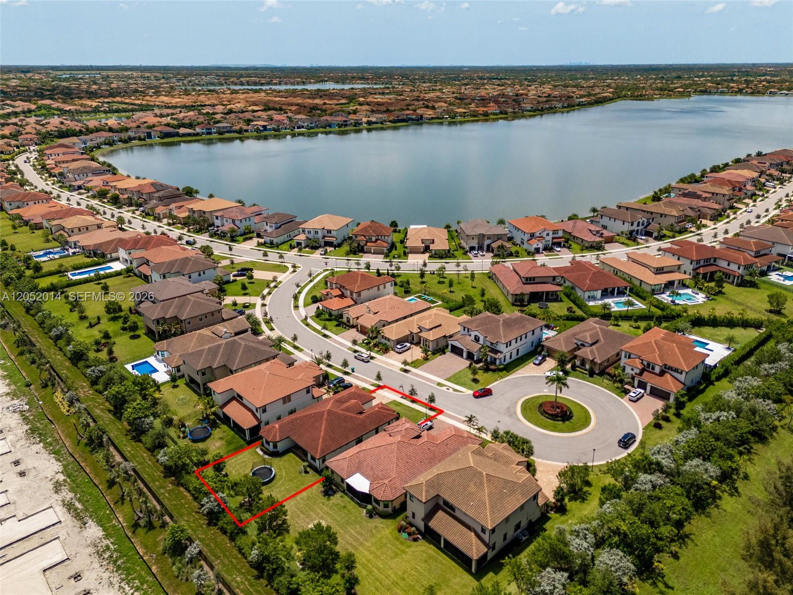 An aerial view shows a residential house with a red-outlined backyard near a lake — 12835 Bayside Ct, Parkland FL 33076, PARKLAND, FL