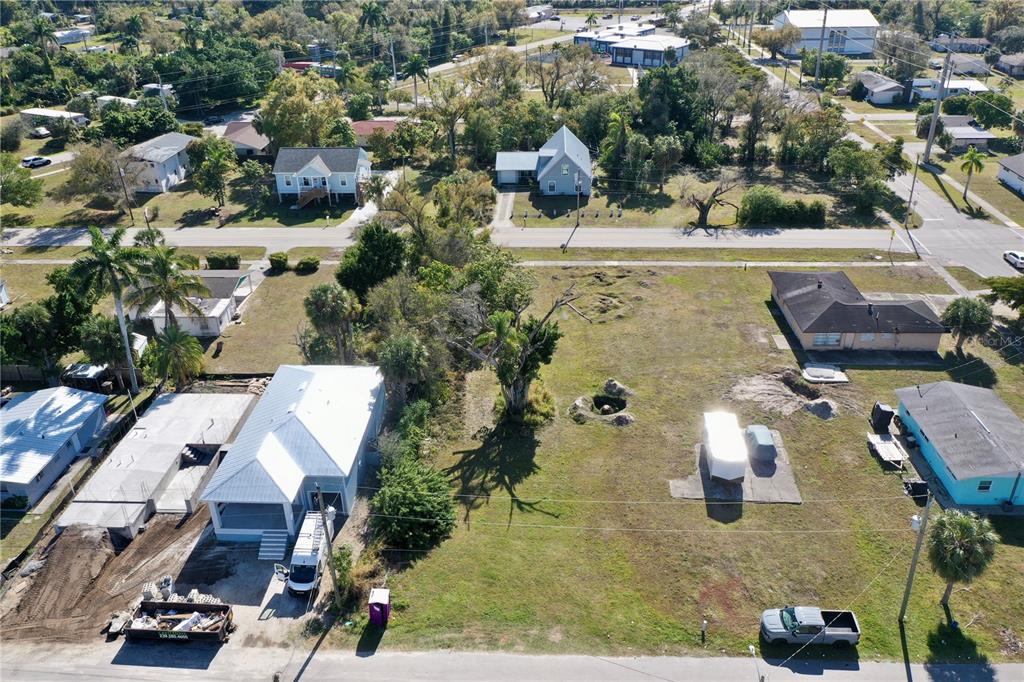 An aerial view shows a vacant lot with a white house and construction debris — 623 FITZHUGH AVENUE, PUNTA GORDA, FL