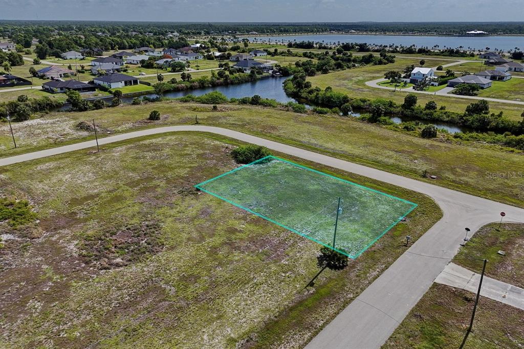 An aerial view shows a vacant, rectangular residential lot outlined in green near a canal — 3801 NW 41ST STREET, CAPE CORAL, FL