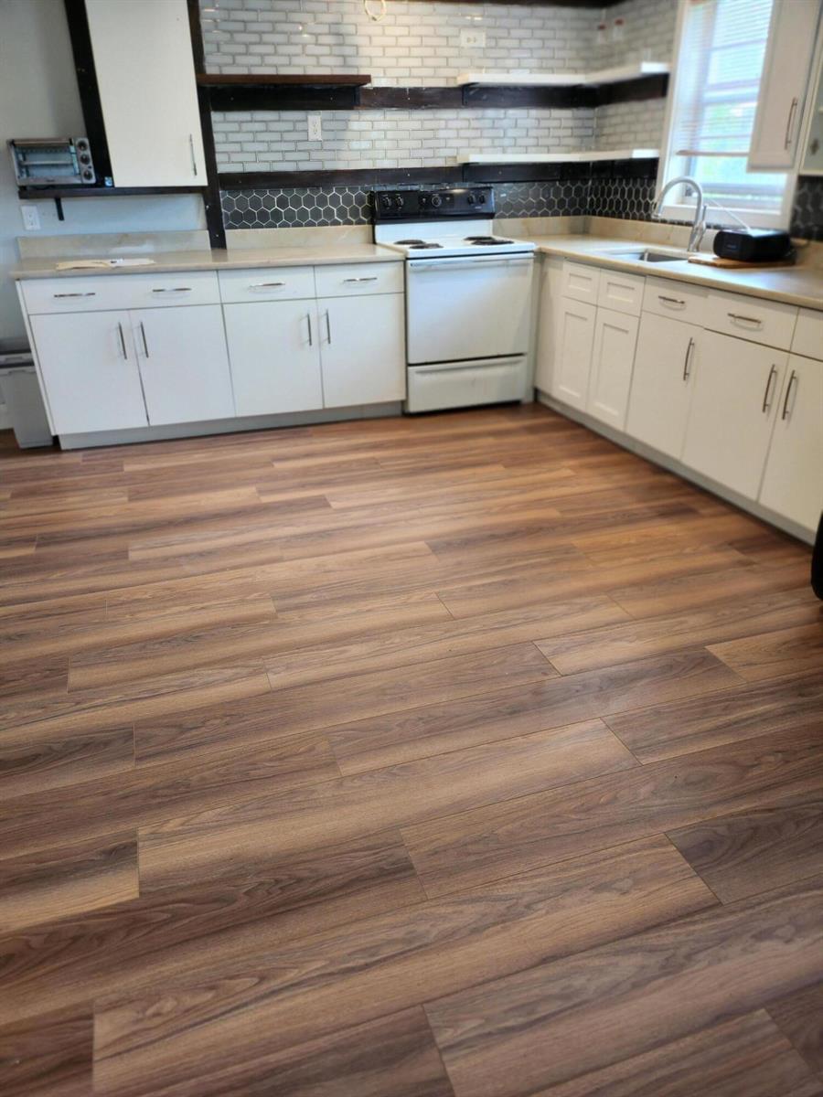 A kitchen with white cabinets, wood-look laminate flooring, and a tiled backsplash — 168 Durham # 168, Deerfield Beach FL 33442, DEERFIELD BEACH, FL