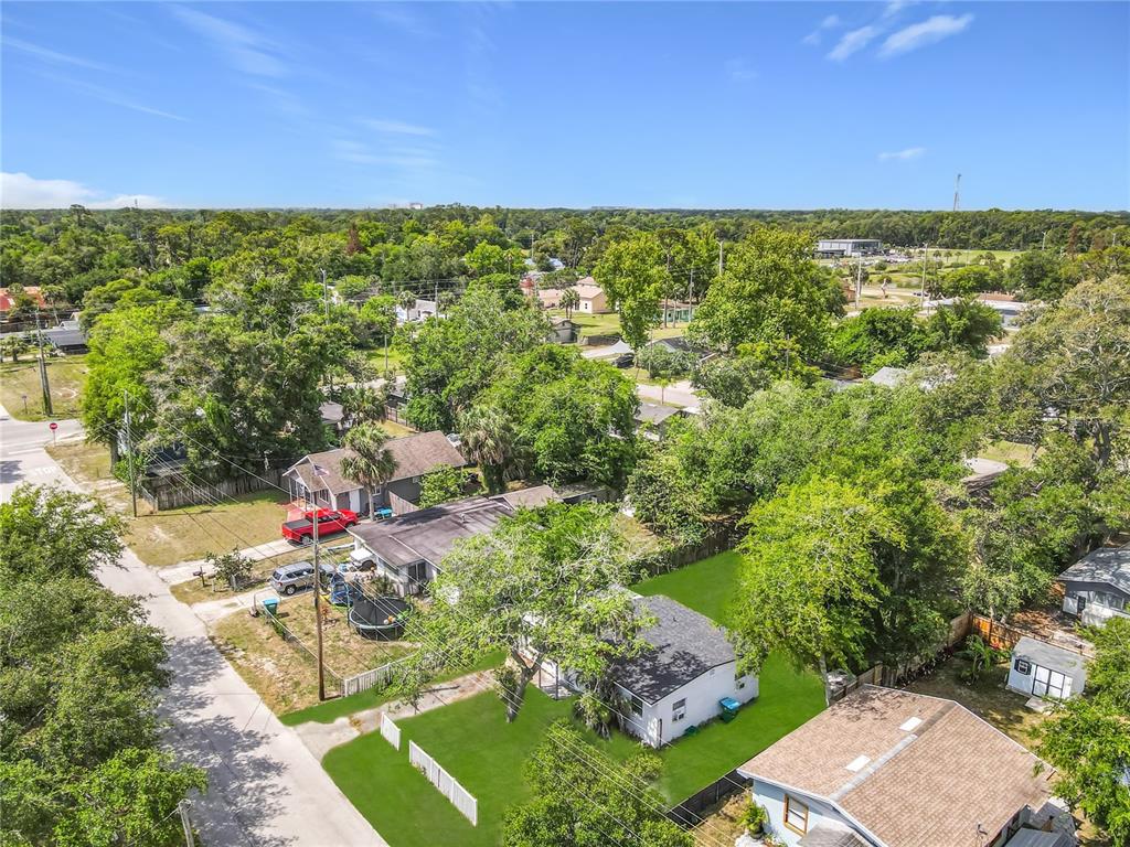 An aerial view shows several single-story houses surrounded by dense trees and green lawns — 1312 JARECKI AVENUE, HOLLY HILL, FL