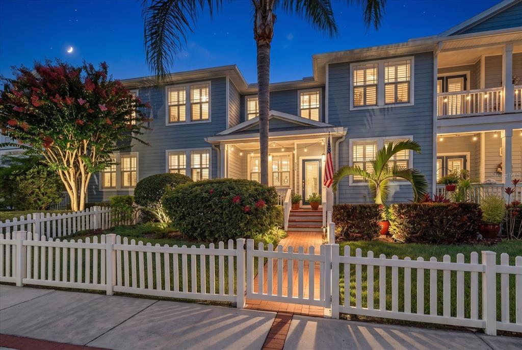 A two-story blue house with a white picket fence and a front porch at dusk — 250 2ND AVENUE SW, LARGO, FL