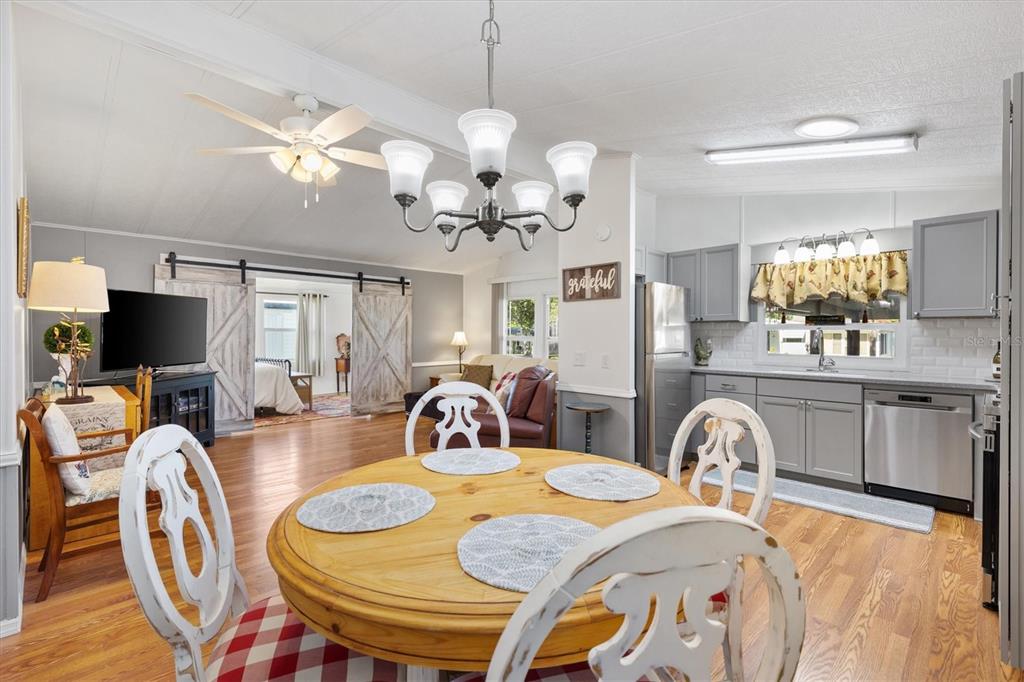 A dining area with a round wooden table sits in front of a gray kitchen — 732 ROYAL PALM AVENUE, LADY LAKE, FL