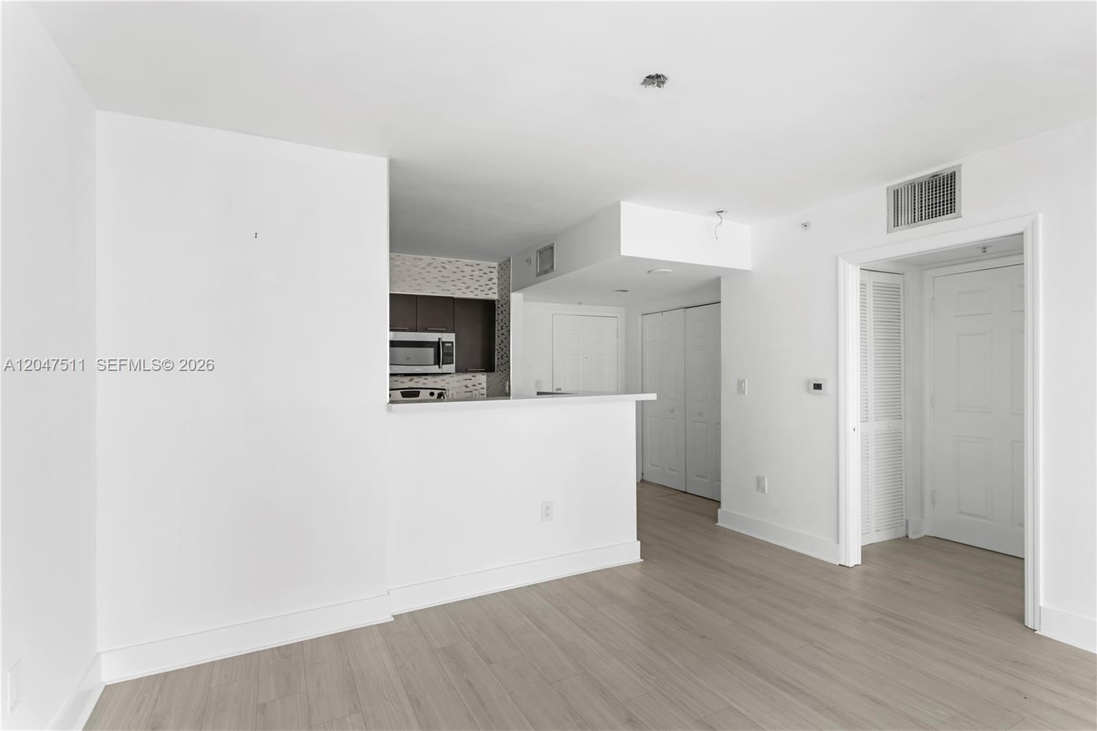 This interior view shows a kitchen with dark cabinets and a white breakfast bar — 1155 Brickell Bay Dr # 3105, Miami FL 33131, MIAMI, FL