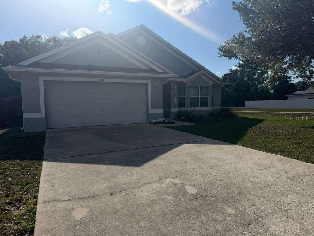 A single-story house with a gray exterior, a two-car garage, and a concrete driveway — 1702 MINNOW COURT, KISSIMMEE, FL