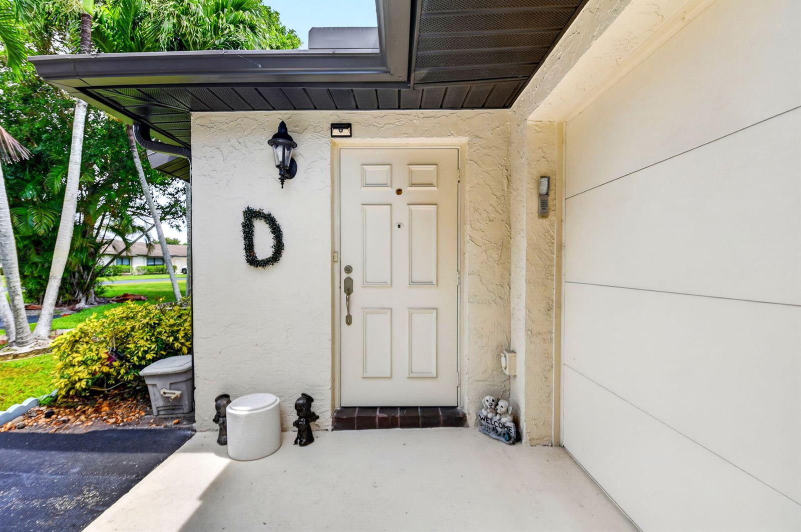 A white front door with a letter D wreath sits under a covered entryway — 4735 Quailwood Way # A, Boynton Beach FL 33436, BOYNTON BEACH, FL
