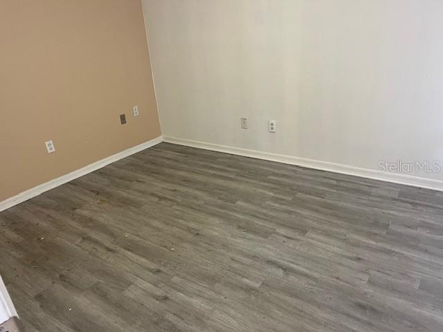 An empty room features light gray wood-look flooring and two-toned beige and white walls — 101 MARGARET STREET UNIT H, BRANDON, FL