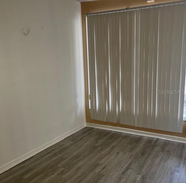 An empty room with light wood-look flooring, white walls, and vertical window blinds — 101 MARGARET STREET UNIT H, BRANDON, FL