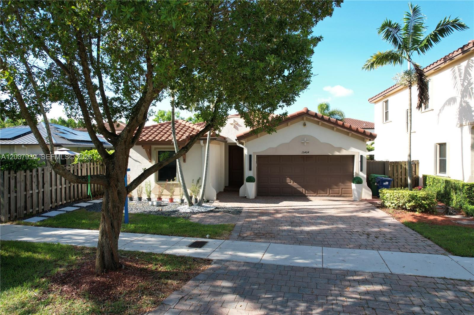 A single-story house with a brown garage door, tile roof, and a paved driveway — 15404 SW 175th St, Miami FL 33187, MIAMI, FL
