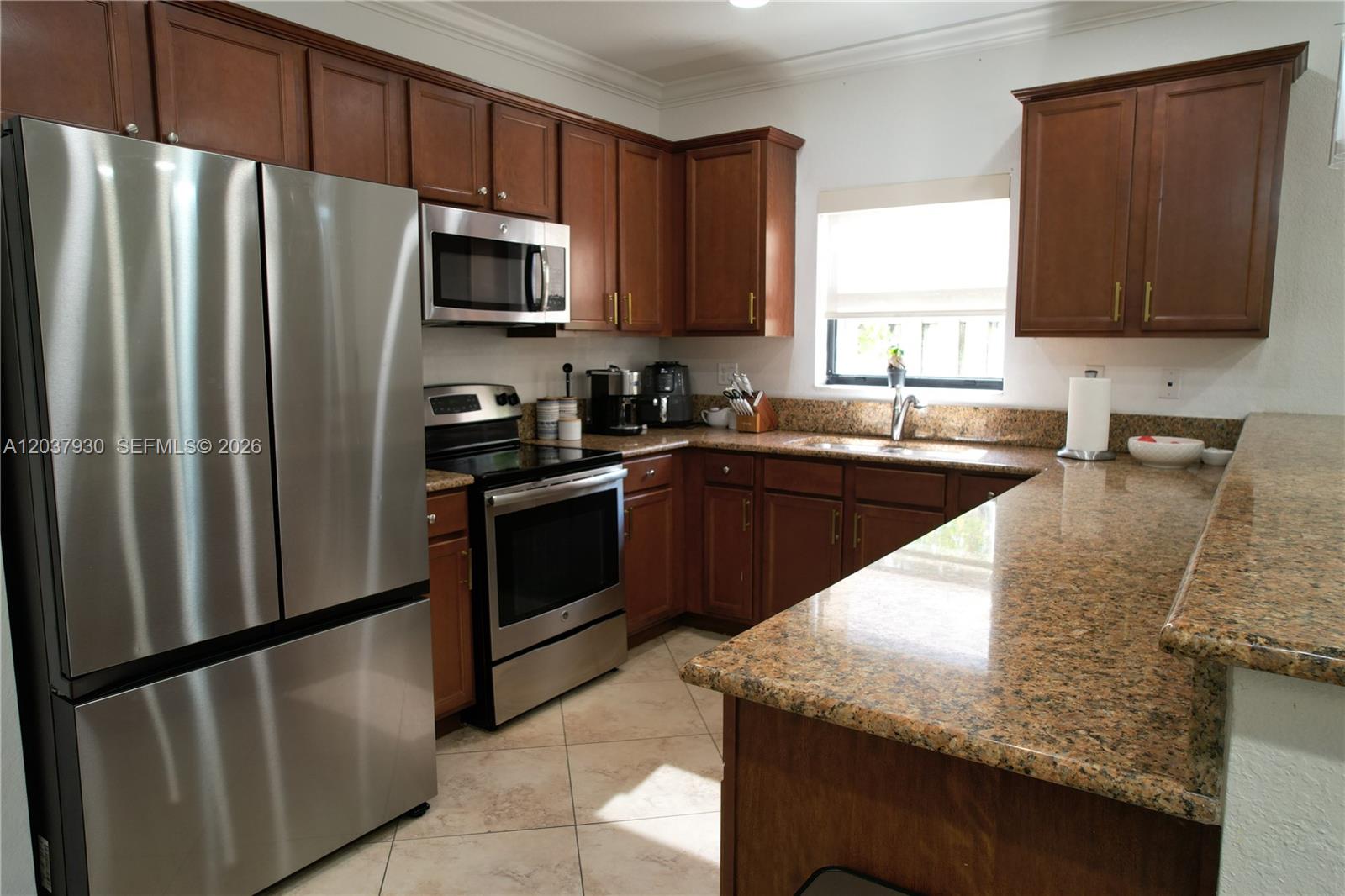 A kitchen features wood cabinets, granite countertops, stainless steel appliances, and tile flooring — 15404 SW 175th St, Miami FL 33187, MIAMI, FL