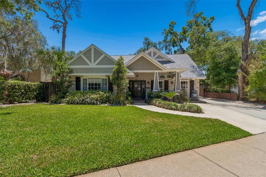 A single-story house with a gabled roof, light-colored siding, and a manicured front lawn — 4528 W WOODMERE ROAD, TAMPA, FL