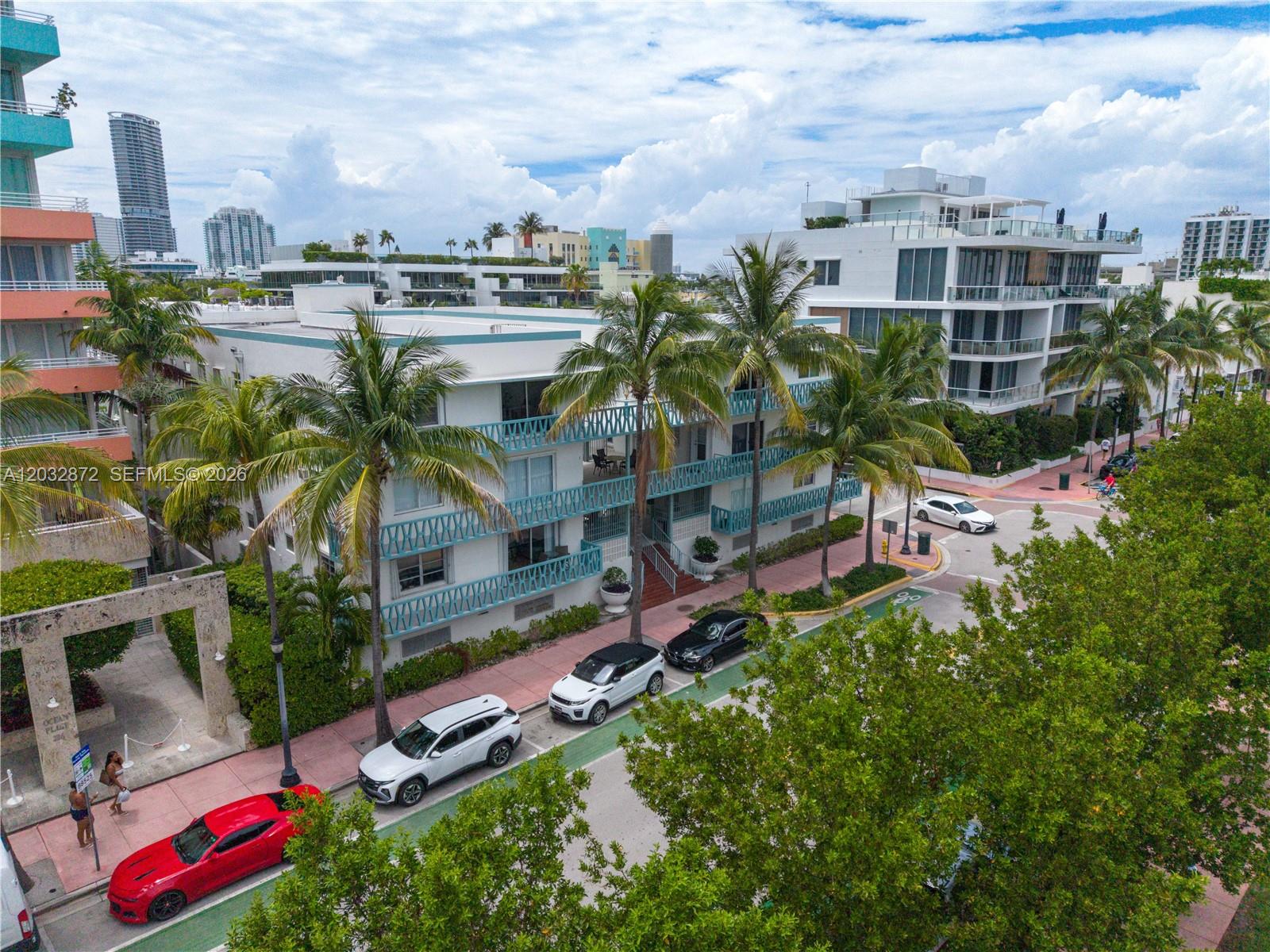 An aerial view shows a multi-story apartment building with palm trees and parked cars — 260 Ocean Dr # 12A, Miami Beach FL 33139, MIAMI BEACH, FL
