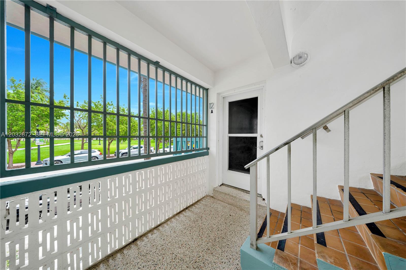 An outdoor landing with stairs, a white door labeled 12A, and a green metal railing — 260 Ocean Dr # 12A, Miami Beach FL 33139, MIAMI BEACH, FL