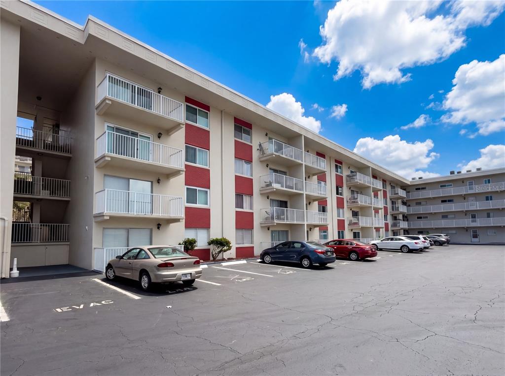A multi-story apartment building with balconies and a parking lot in the foreground — 2711 N HALIFAX AVENUE UNIT 371, DAYTONA BEACH, FL