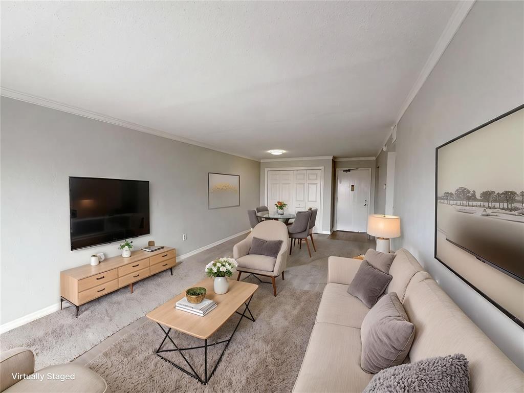 A living room with a television, sofa, coffee table, and a dining area in the background — 2711 N HALIFAX AVENUE UNIT 371, DAYTONA BEACH, FL