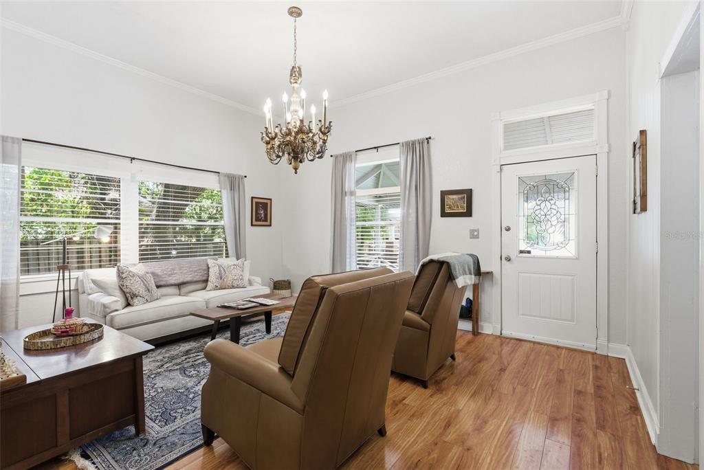 A living room features hardwood floors, a chandelier, a white sofa, and two leather recliners — 3017 N WOODROW AVENUE, TAMPA, FL