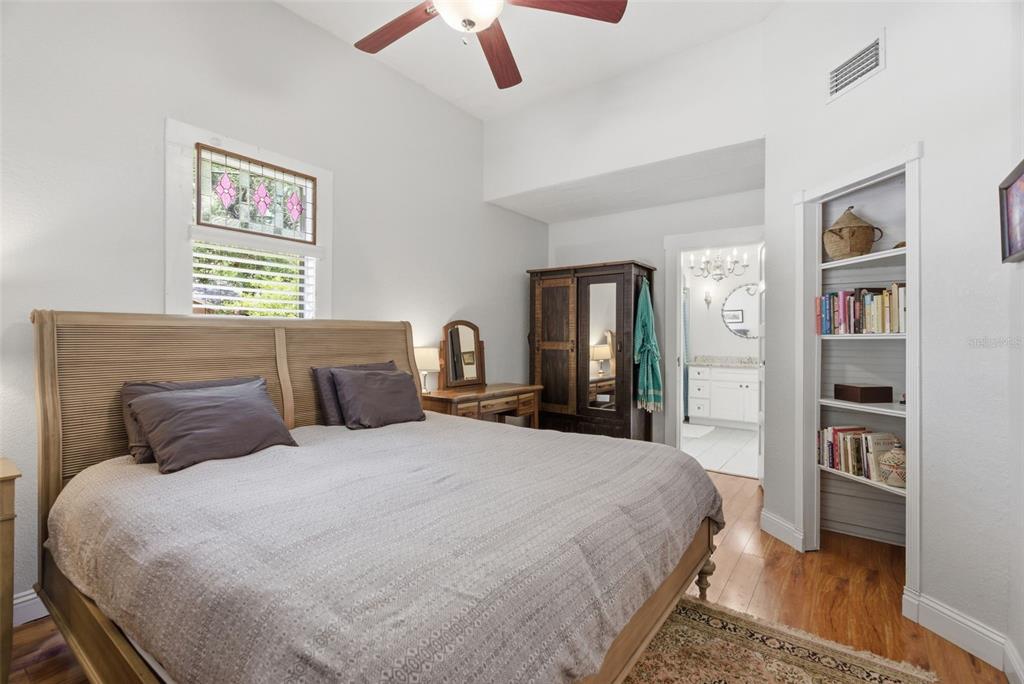 A bedroom features a wooden bed, a built-in bookshelf, and an attached bathroom — 3017 N WOODROW AVENUE, TAMPA, FL