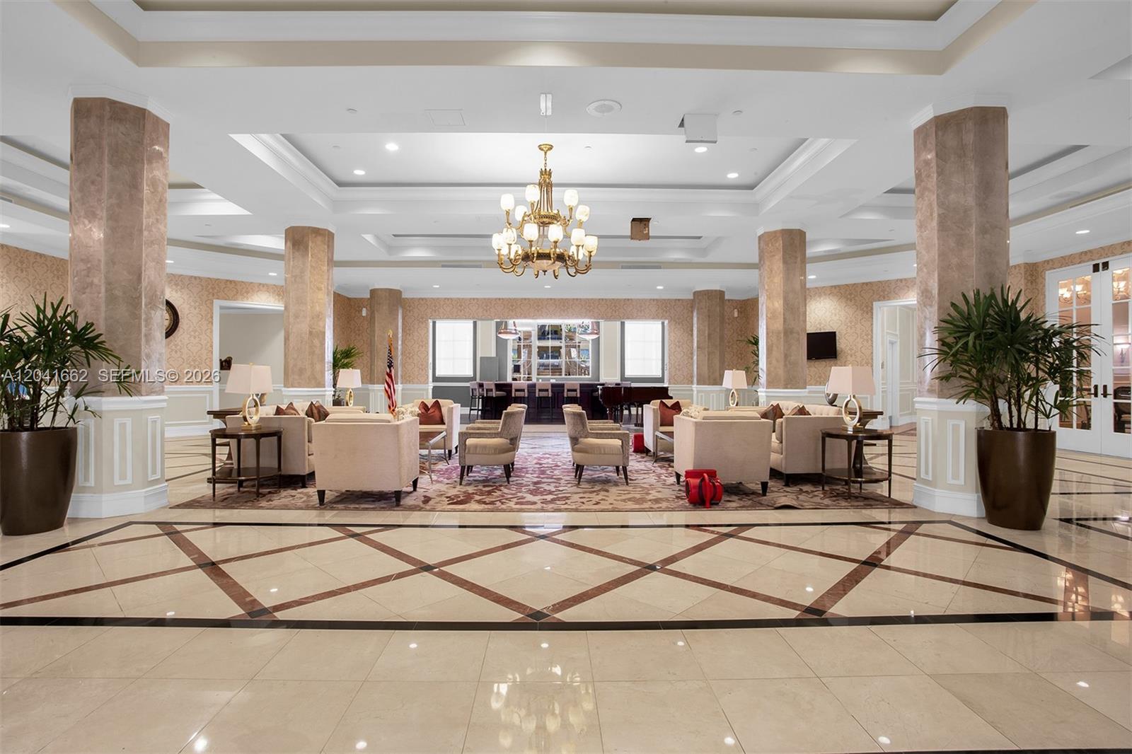 A spacious, tiled lobby features marble columns, a large chandelier, and multiple seating areas — 16101 Emerald Estates Dr # 155, Weston FL 33331, WESTON, FL