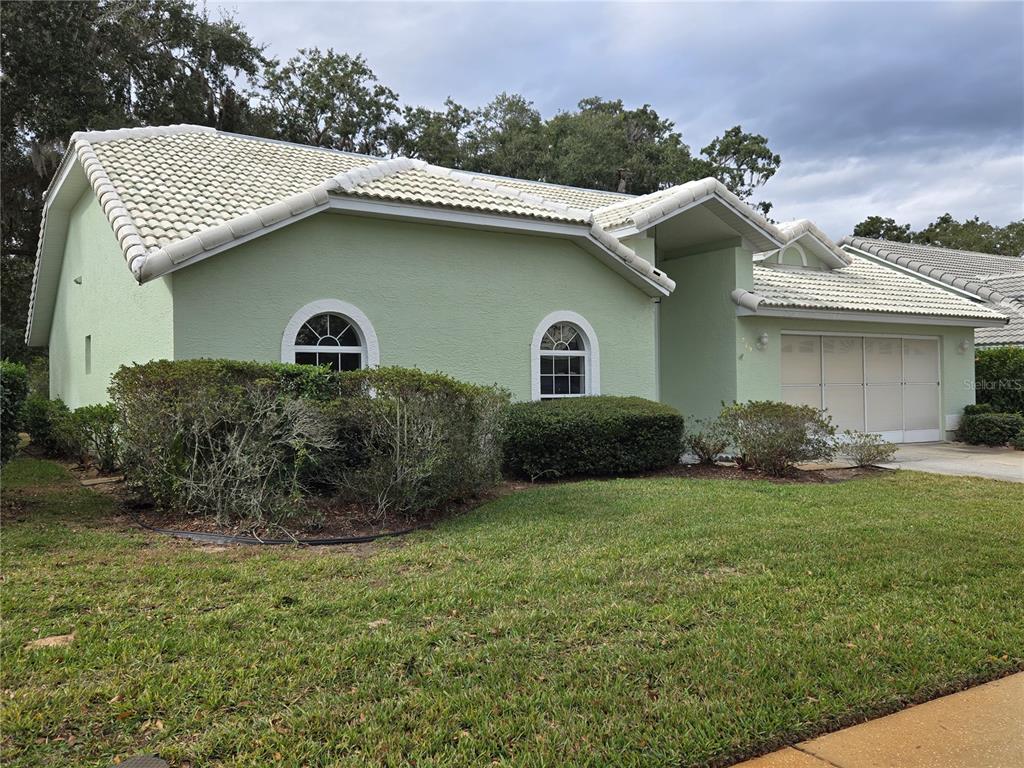 A light green single-story house with a white tile roof and an attached garage — 719 BALMORAL COURT, INVERNESS, FL