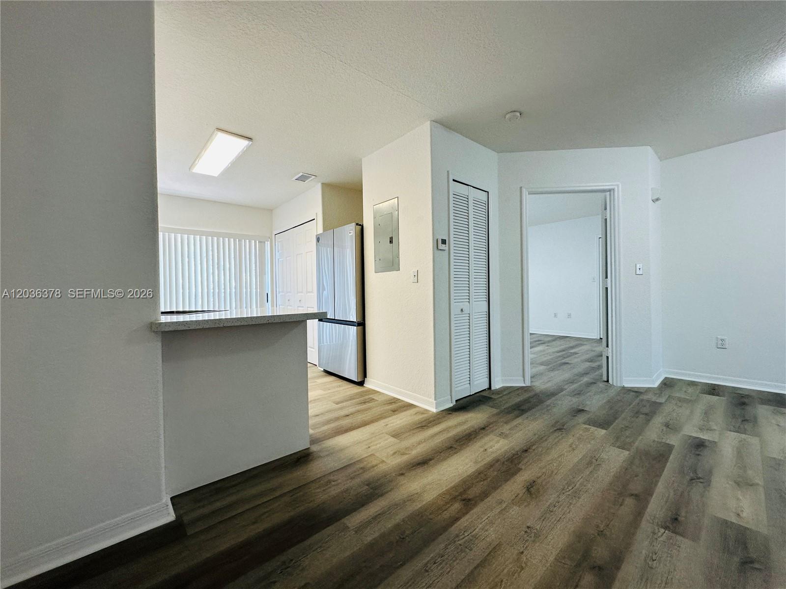A kitchen with a breakfast bar and stainless steel refrigerator opens to an adjacent room — 5705 NW 109th Ave # 50, Doral FL 33178, DORAL, FL