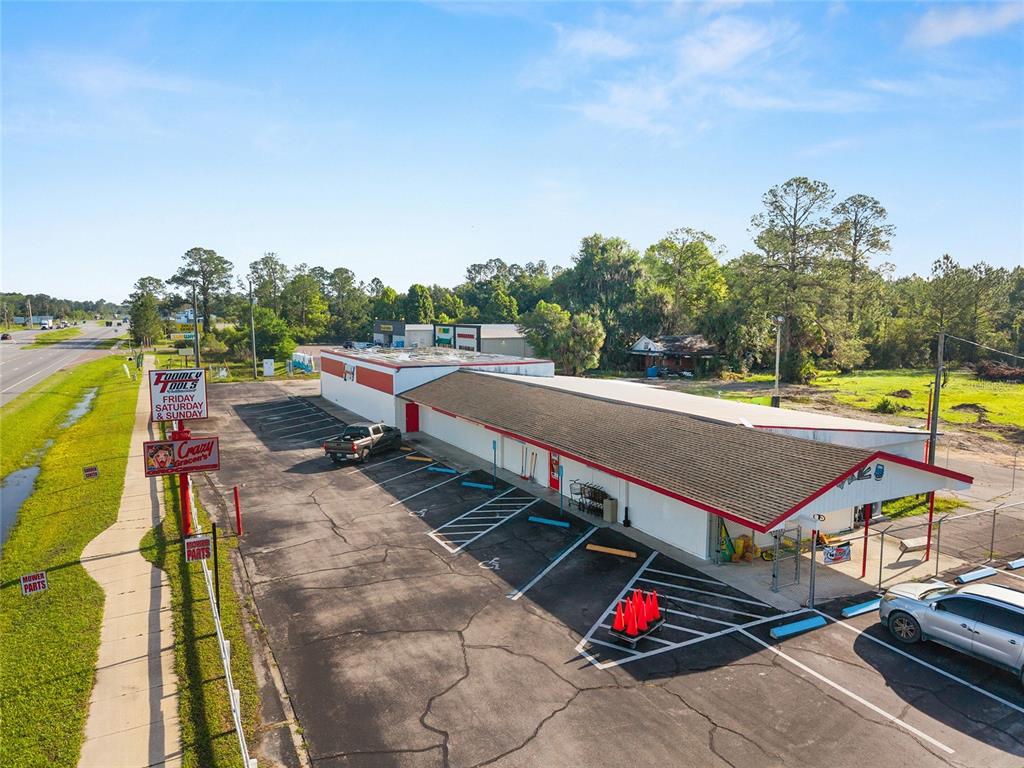 An aerial view shows a commercial building with a parking lot and signage — 17313 NE US HWY 301, WALDO, FL