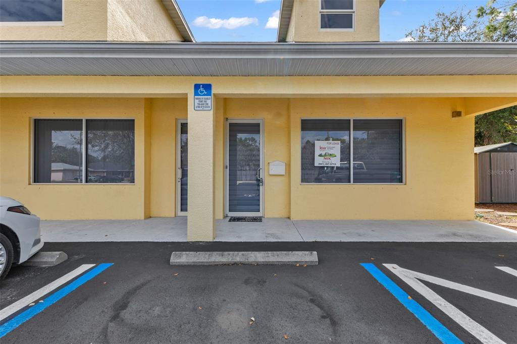 The exterior of a yellow commercial building features a central entrance and two large windows — 493 BARGER DRIVE, PORT CHARLOTTE, FL