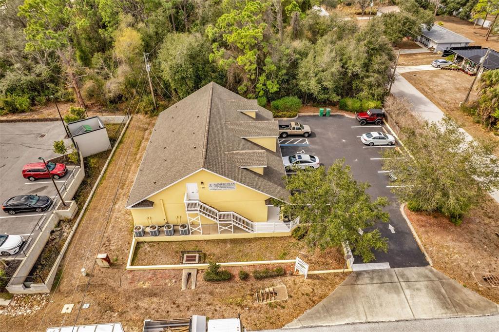 An aerial view shows a yellow commercial building with a parking lot and surrounding trees — 493 BARGER DRIVE, PORT CHARLOTTE, FL