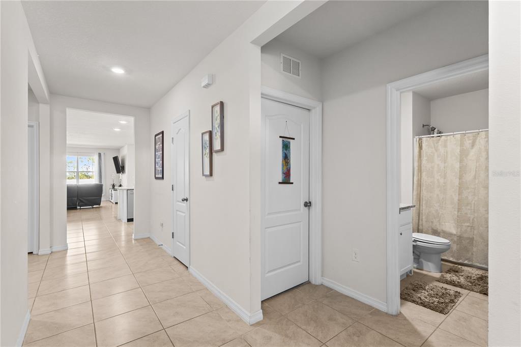 A tiled hallway leads to a living area with a bathroom on the right — 547 TANARO LANE, HAINES CITY, FL