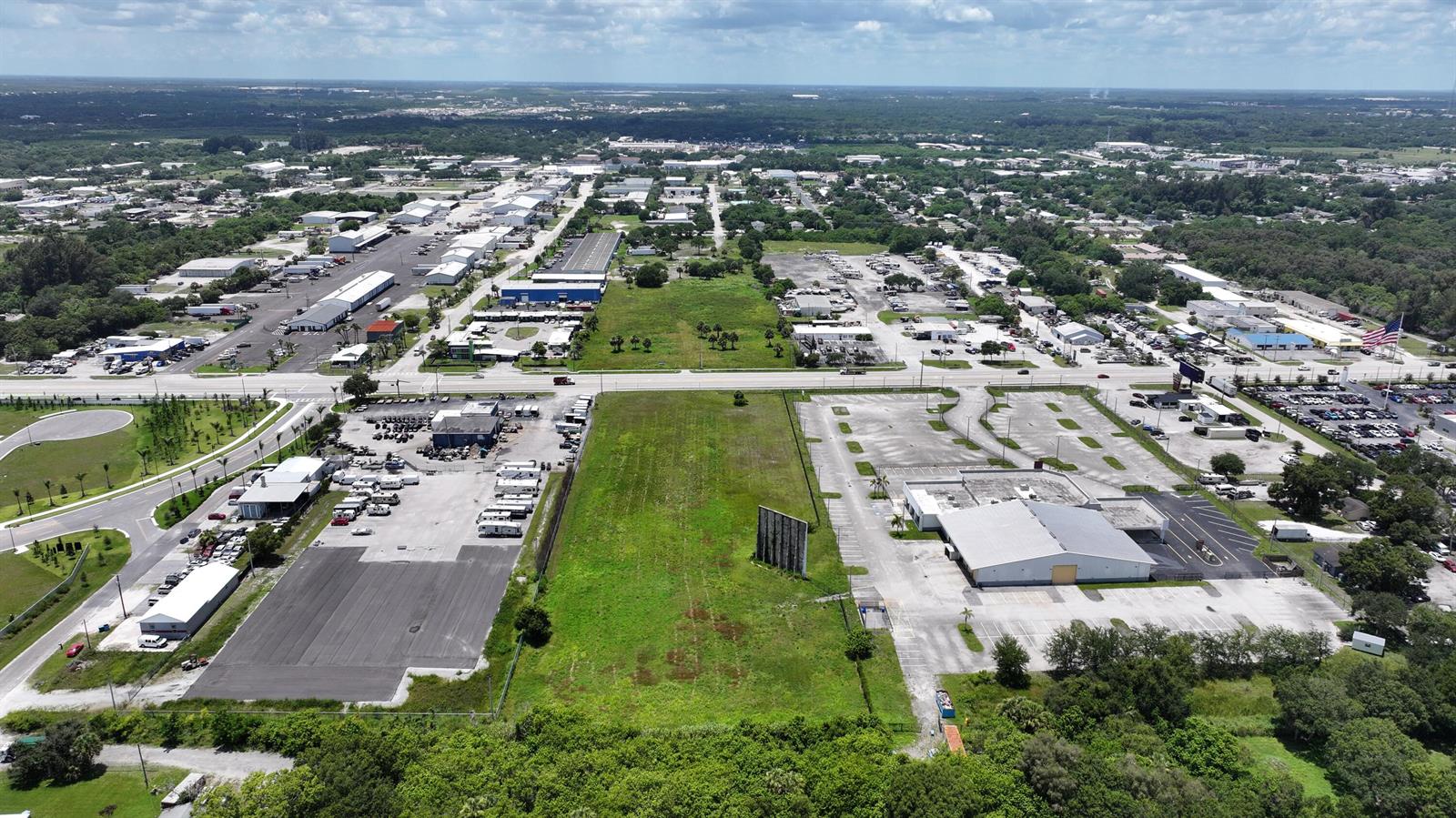 An aerial view shows a large vacant lot situated between two commercial properties and parking lots — 3450 S US Highway 1, Fort Pierce FL 34982, FORT PIERCE, FL