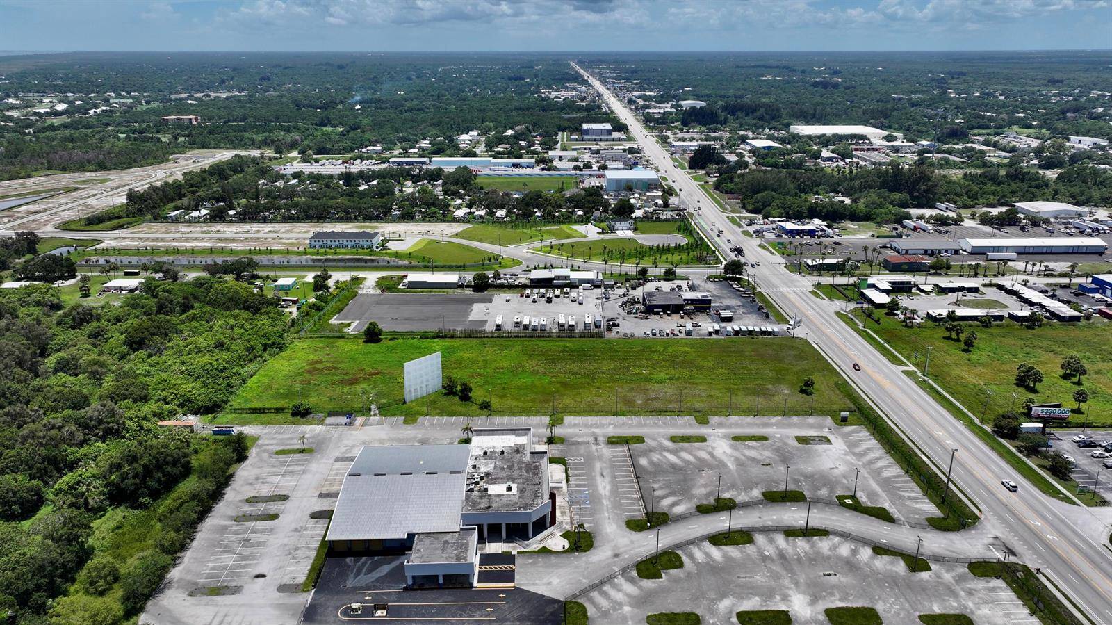 An aerial view shows a commercial building with a large parking lot and adjacent land — 3450 S US Highway 1, Fort Pierce FL 34982, FORT PIERCE, FL