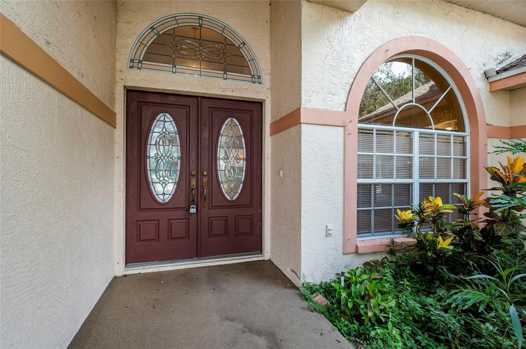 A front entryway features a double door with glass inserts and an arched transom window — 1336 WATERWOOD DRIVE, LUTZ, FL