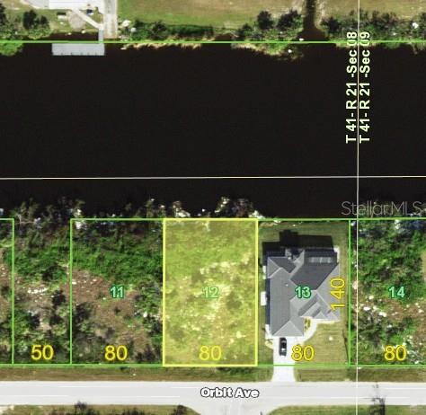 This aerial map shows a vacant rectangular waterfront lot situated between two residential properties — 13994 ORBIT AVE, PORT CHARLOTTE, FL