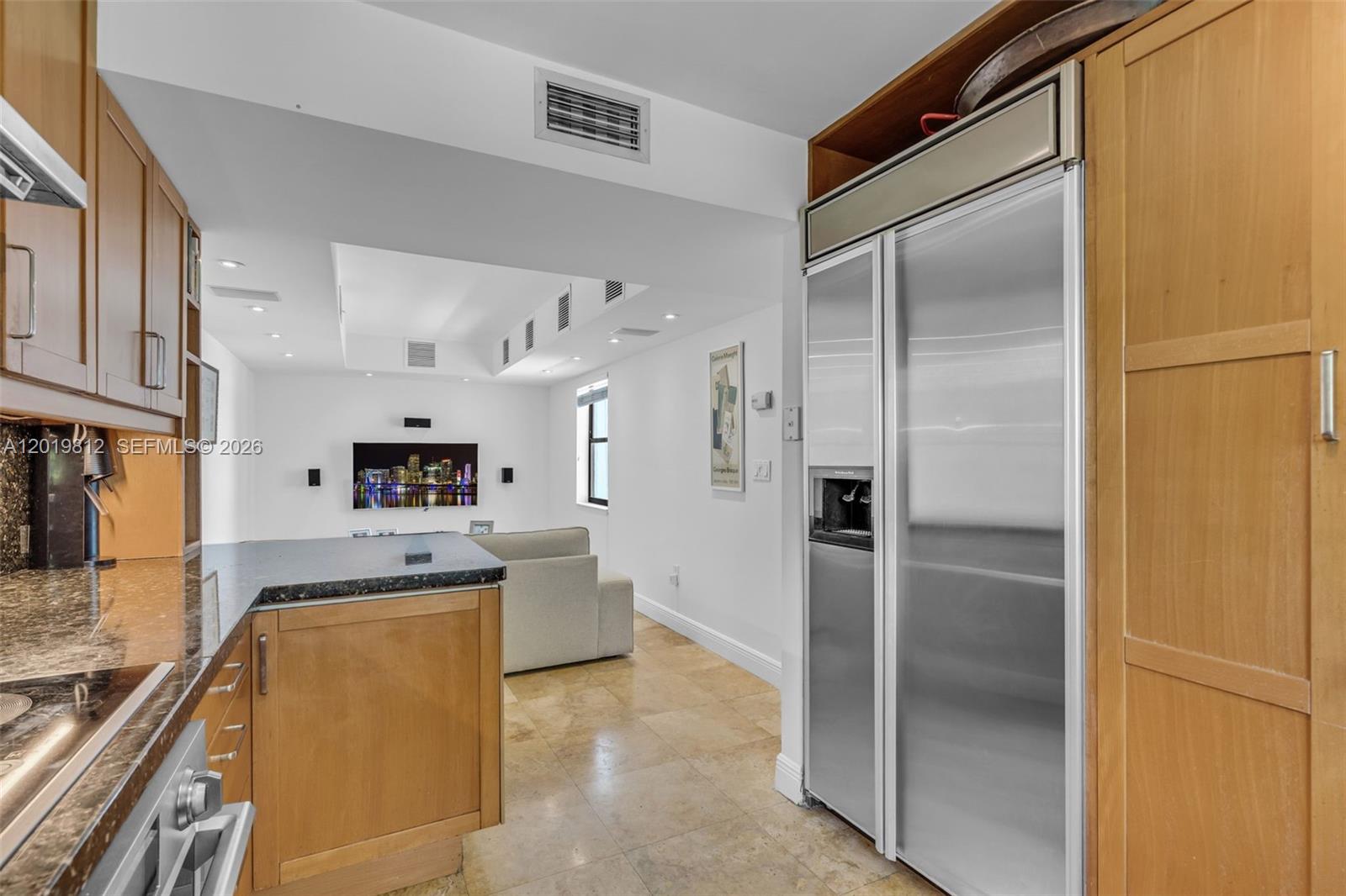 A kitchen with wood cabinets and granite countertops opens into a living area with tile floors — 209 E Enid Dr # 36, Key Biscayne FL 33149, KEY BISCAYNE, FL
