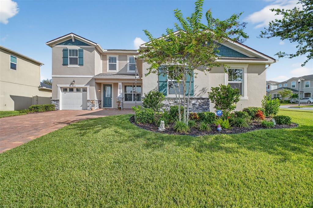 A two-story suburban house with a paved driveway, stone accents, and a landscaped front yard — 3222 FIDDLEWOOD CT, CLERMONT, FL