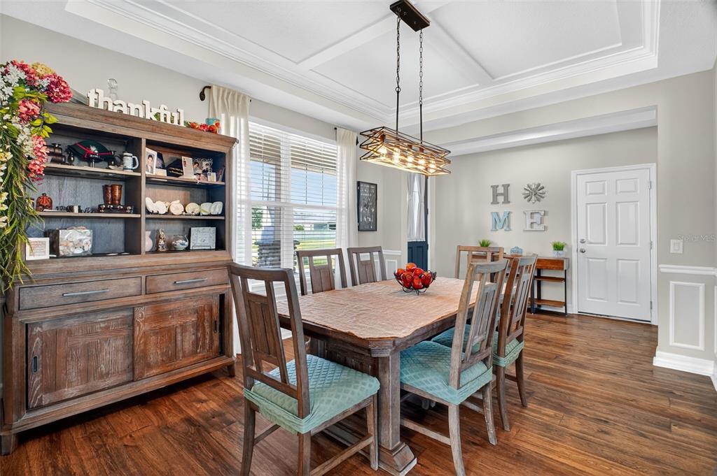 A dining room features a wooden table, chairs with teal cushions, and a hutch — 3222 FIDDLEWOOD CT, CLERMONT, FL