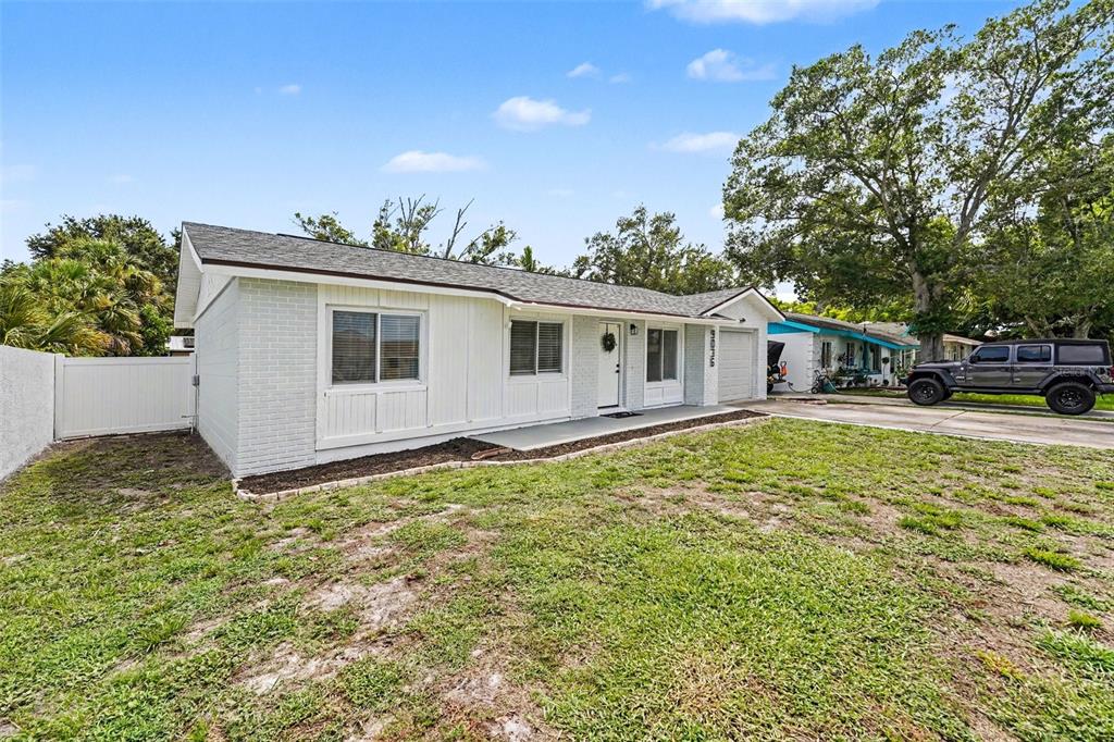 A living room with light wood flooring, a beige sofa, and a round wooden coffee table — 9036 109TH TERRACE, SEMINOLE, FL