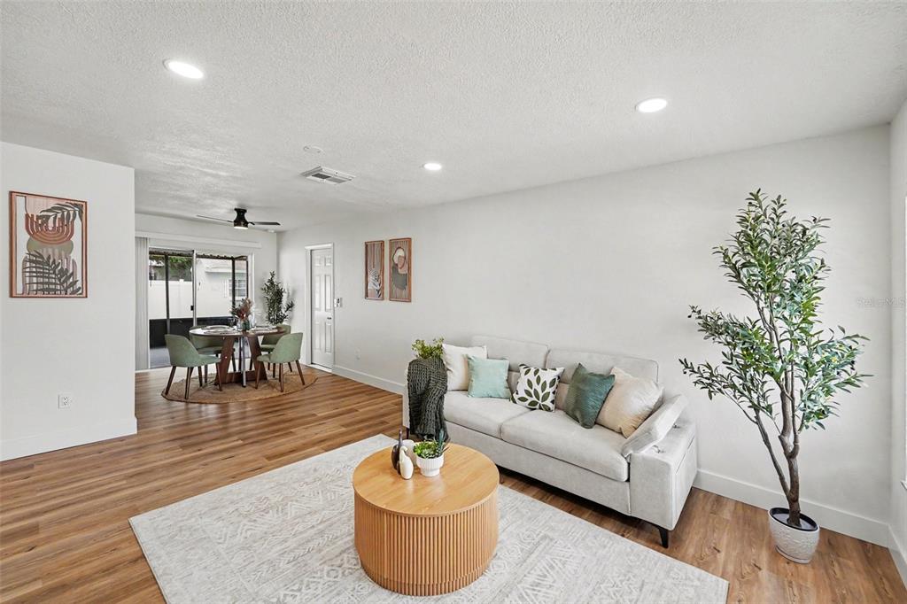 A dining area with a round wooden table, green chairs, and a sliding glass door — 9036 109TH TERRACE, SEMINOLE, FL