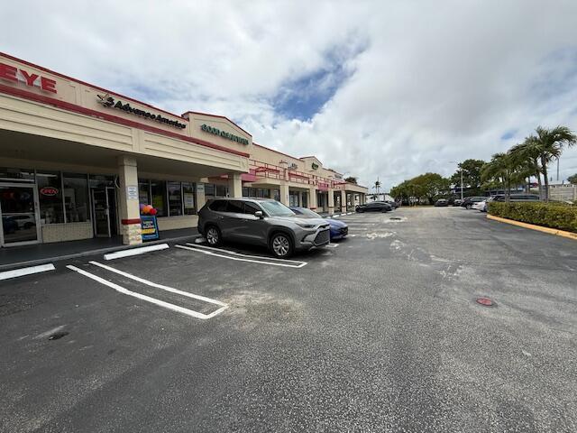 A gray SUV is parked in front of a strip mall under a cloudy sky — 958 Northlake Boulevard, Lake Park FL 33403, LAKE PARK, FL
