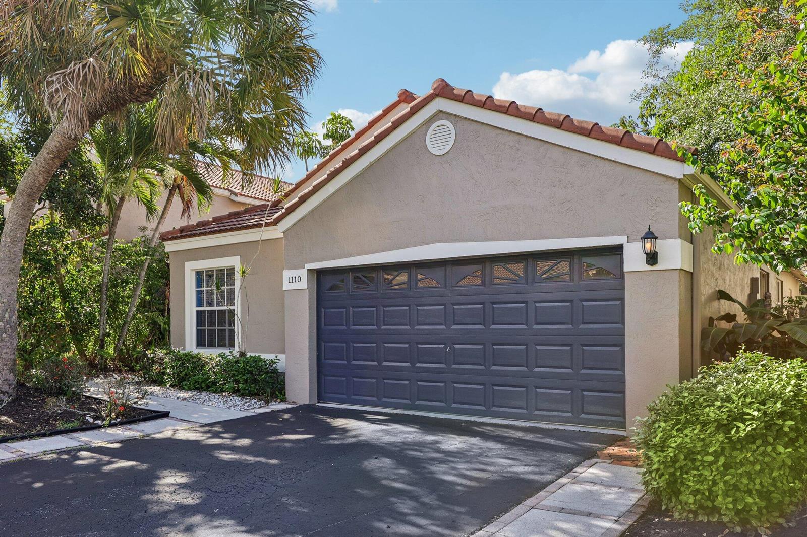 A tan stucco house with a dark gray garage door and a tiled roof — 1110 NW 105th Way, Plantation FL 33322, PLANTATION, FL