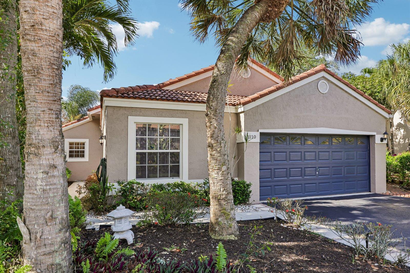 A single-story house with a blue garage door, tile roof, and palm trees in front — 1110 NW 105th Way, Plantation FL 33322, PLANTATION, FL