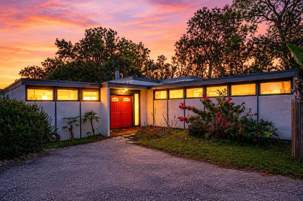 A screened-in pool area features a wooden deck, stone accents, and a hot tub — 7990 42ND STREET N, PINELLAS PARK, FL