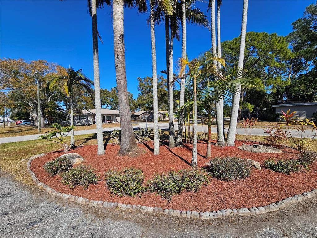 A single-story house with a flat roof, red double doors, and clerestory windows at sunset — 7990 42ND STREET N, PINELLAS PARK, FL