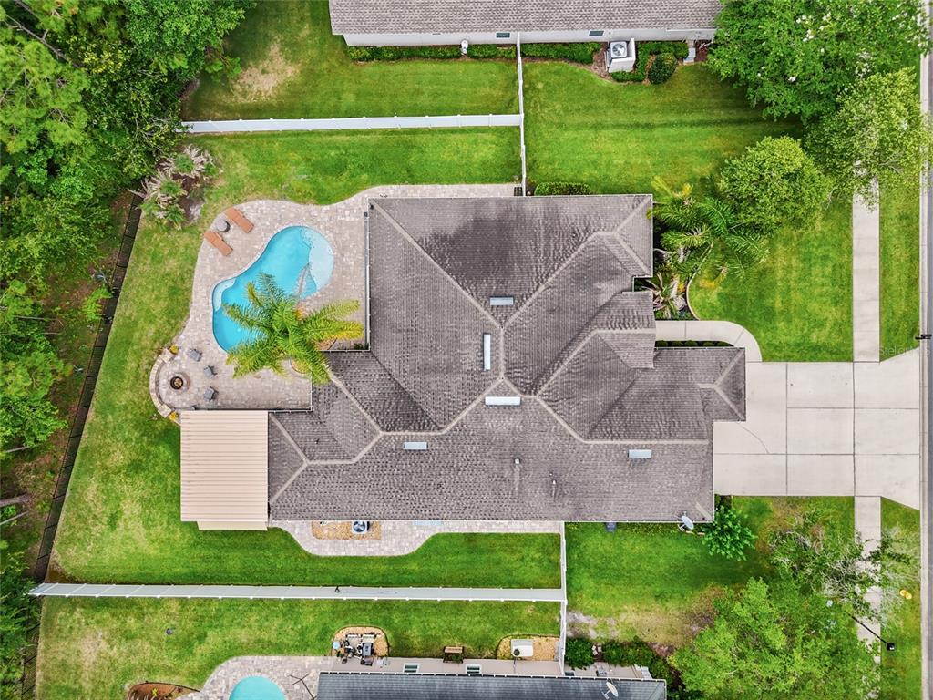 An aerial view shows a house with a shingled roof, swimming pool, and backyard patio — 245 WORTHINGTON PARKWAY, ST JOHNS, FL