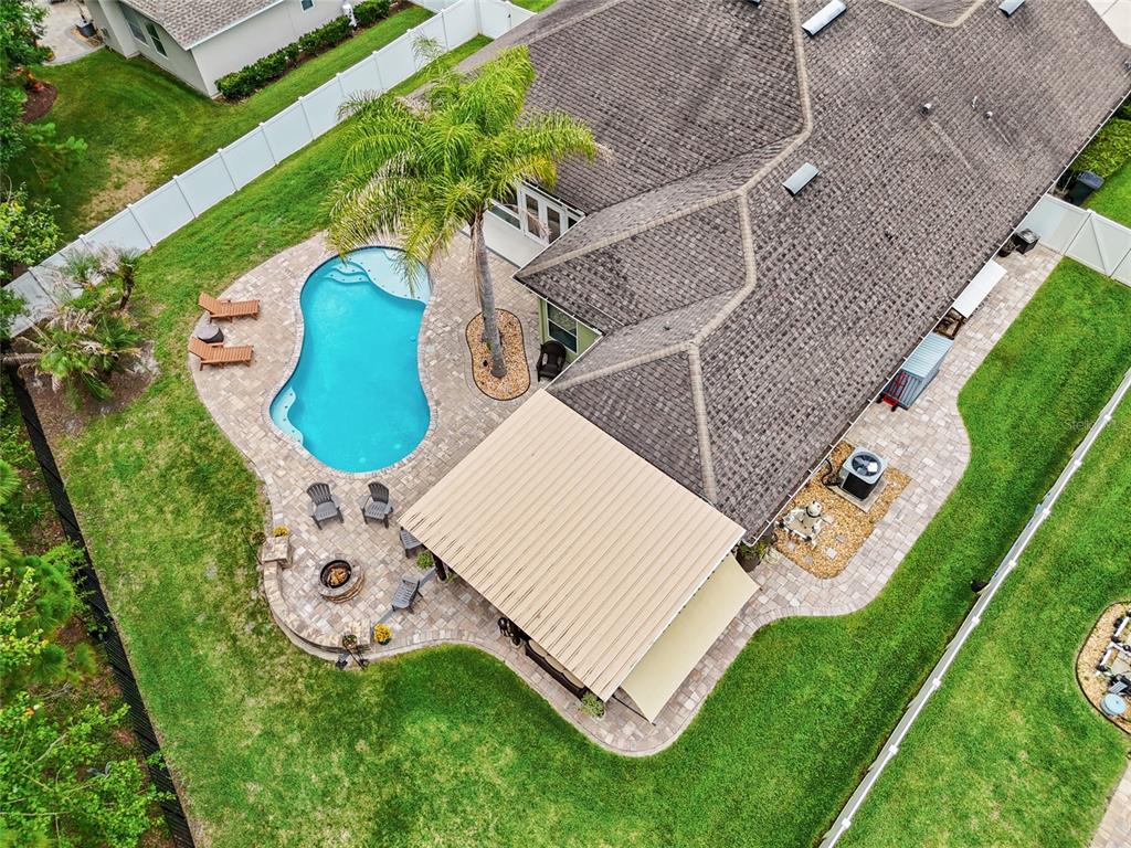 An aerial view shows a house with a swimming pool, patio, and fire pit area — 245 WORTHINGTON PARKWAY, ST JOHNS, FL