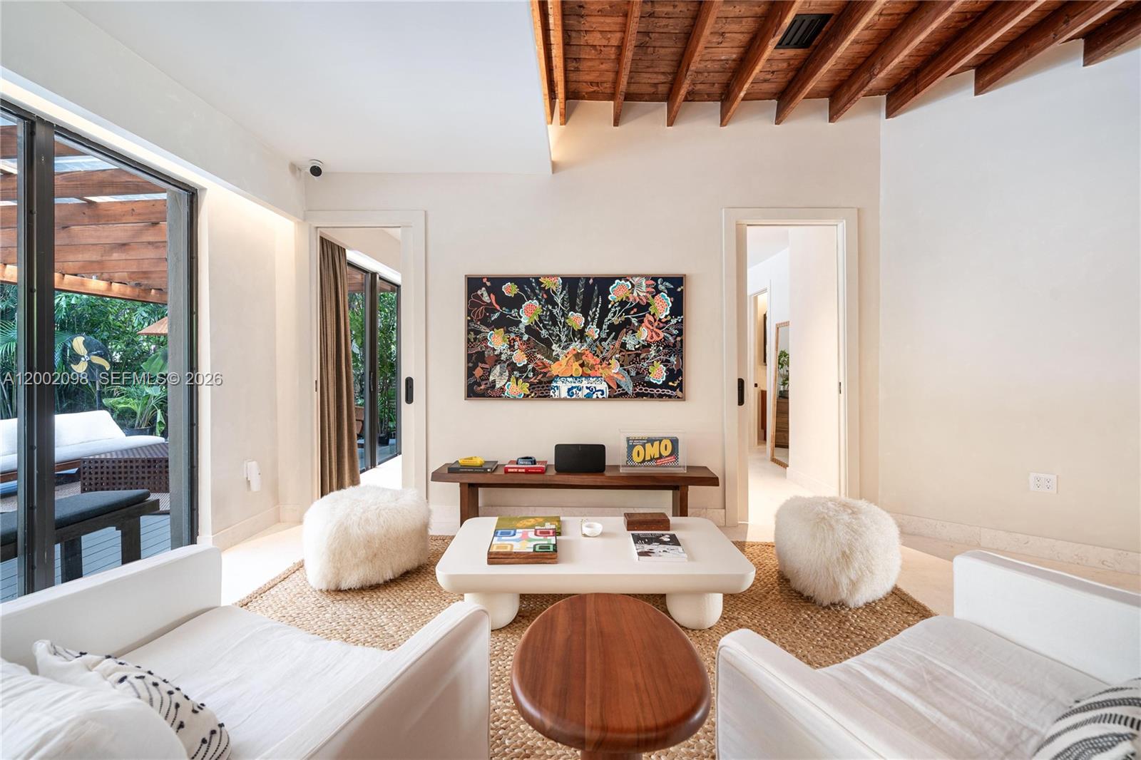 A living room features white armchairs, a central coffee table, and a wooden ceiling — 1735 Michigan Ave, Miami Beach FL 33139, MIAMI BEACH, FL