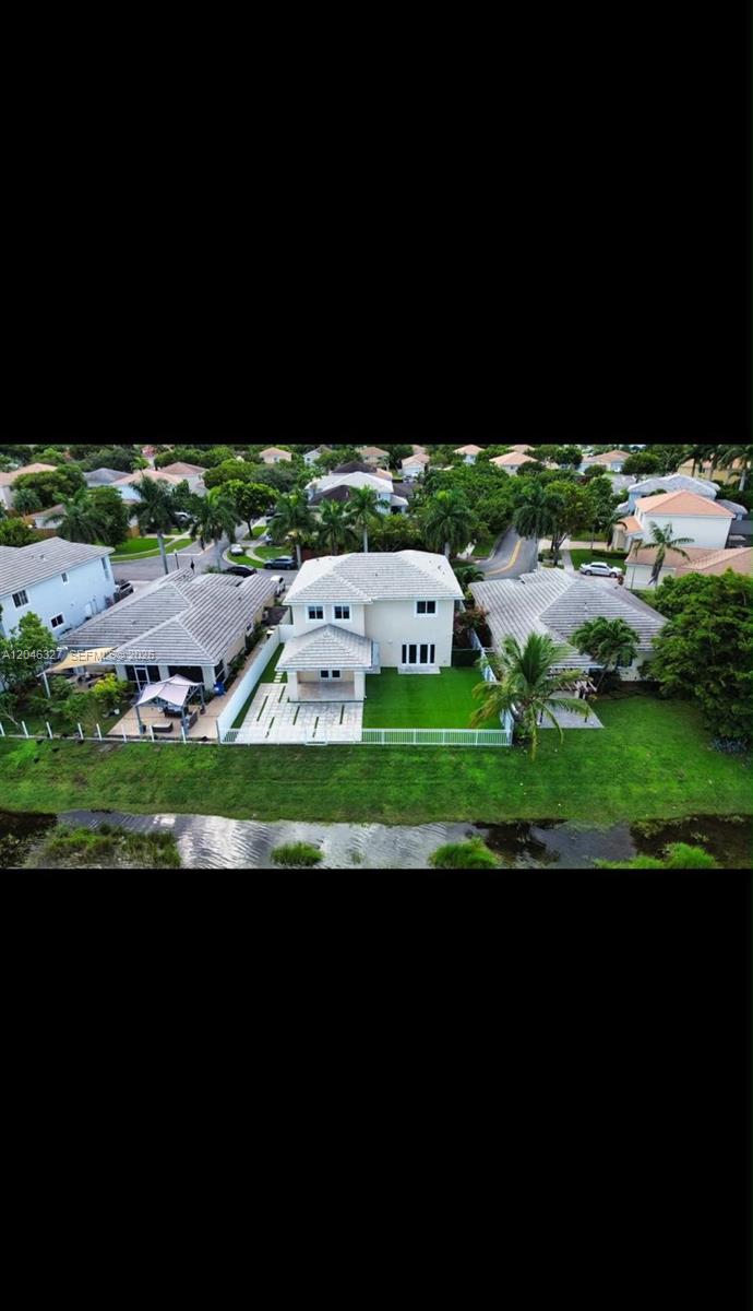 An aerial view shows a two-story house with a tiled roof, patio, and fenced yard — 449 SE 31st Ave, Homestead FL 33033, HOMESTEAD, FL