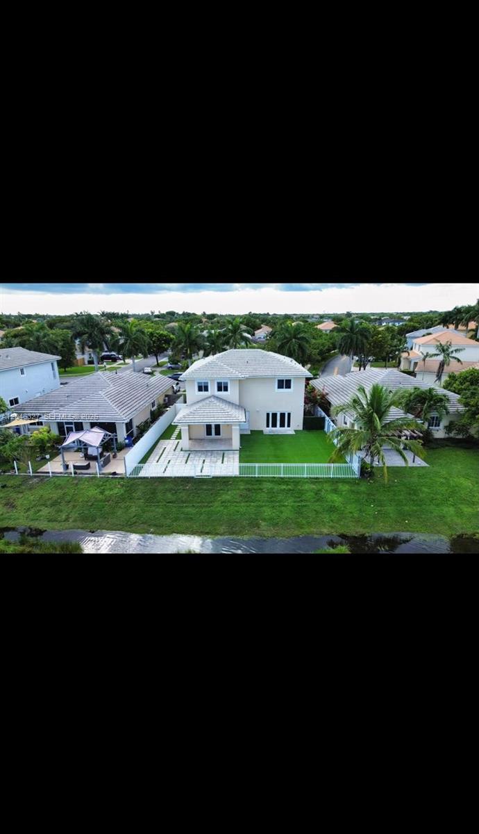 An aerial view of a two-story house with a fenced backyard and a patio — 449 SE 31st Ave, Homestead FL 33033, HOMESTEAD, FL