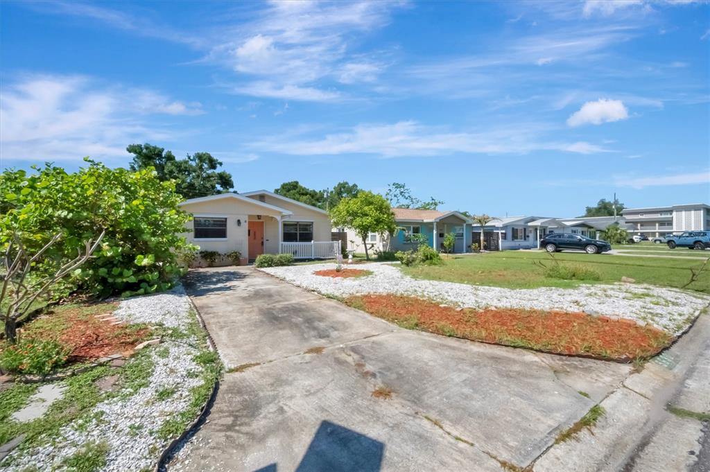 A single-story house with a concrete driveway and a front yard featuring white gravel — 5630 13TH AVENUE N, ST PETERSBURG, FL