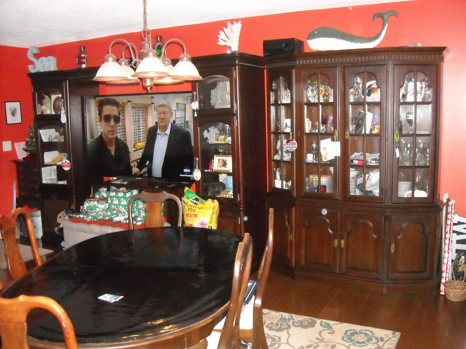 A dining room features a dark wood hutch, a black table, and bright red walls — 216 Sheffield I, West Palm Beach FL 33417, WEST PALM BEACH, FL