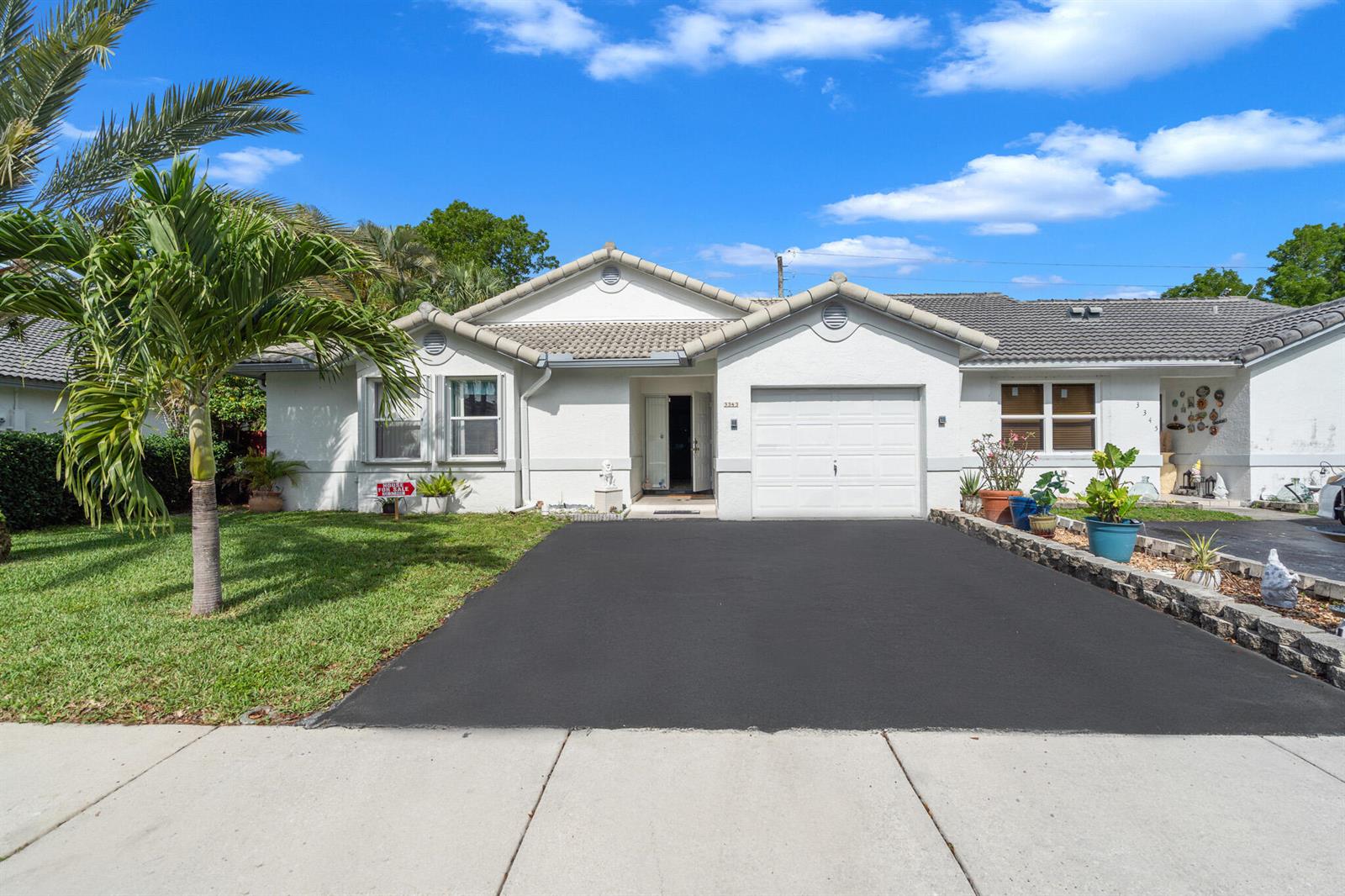 A single-story house with a white stucco exterior, a garage, and a paved driveway — 3343 NW 79th Way, Davie FL 33024, DAVIE, FL
